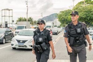 dois policiais utilizando 2 baterias de câmeras corporais